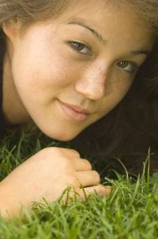 Portrait of a young woman lying on the grass