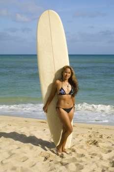 Young woman standing with a surfboard