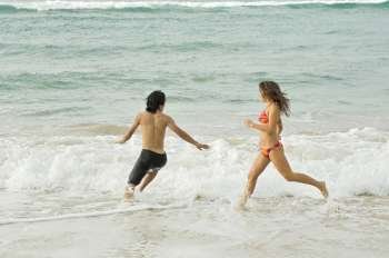 Young couple running in water