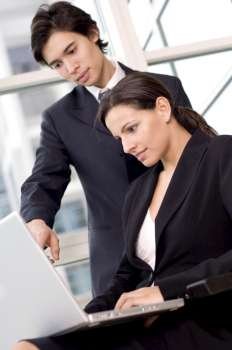 Side profile of a businesswoman and a businessman looking at a laptop