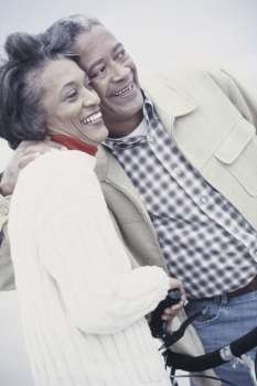 Senior couple holding each other smiling