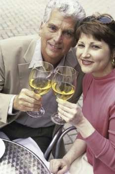 Portrait of a mid adult couple toasting with white wine