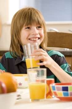 Boy holding a glass of orange juice and smiling