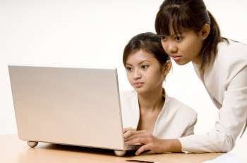 Two teenage girls looking at a laptop