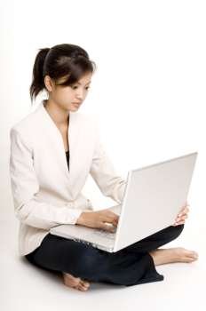 Teenage girl sitting on the floor and using a laptop