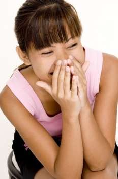 Teenage girl covering her mouth with her hands