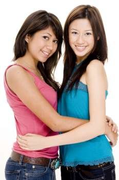 Two young women hugging each other and smiling