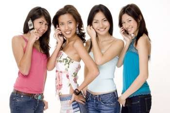 Four young women talking on mobile phones
