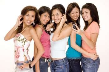 Four young women and a teenage girl using MP3 players and mobile phones