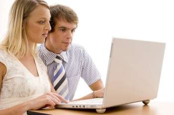 Businesswoman and a businessman looking at a laptop