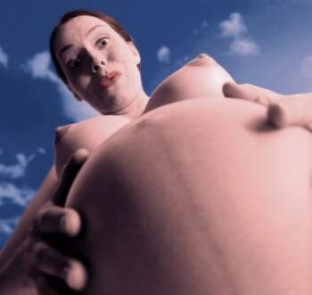 Low angle view of a young pregnant woman touching her abdomen