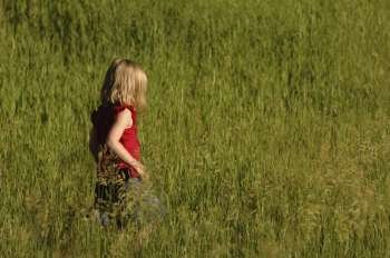 Child walking though tall grass