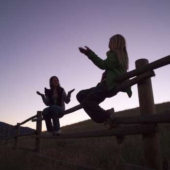 Silhouette of girls on fence