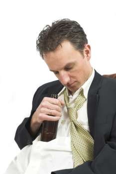 Businessman falling asleep with his beer bottle this in his hand