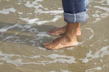 Pretty woman standing barefoot in the sea