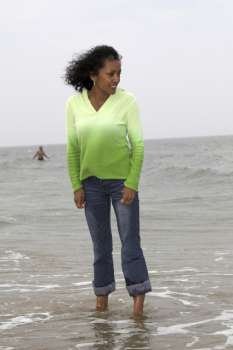 Beautiful black woman trying out the temperature of the water