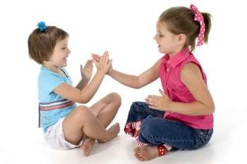 Two sisters, 4 and 6, playing clapping games.