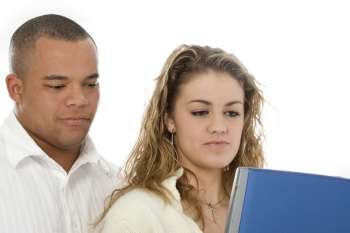 Attractive young couple looking at laptop computer. Shot in studio over white.