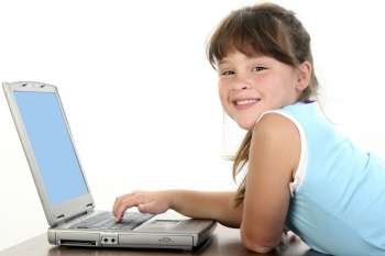 Adorable little girl working on laptop computer. 