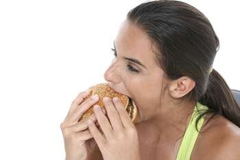 Beautiful Teen Girl Eating a Giant Cheeseburger after a workout. 