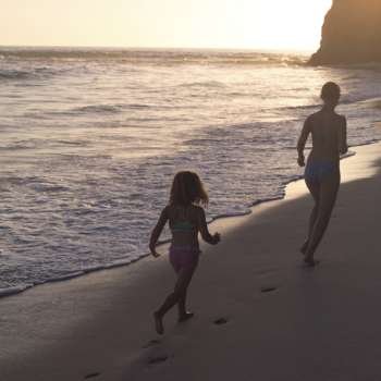 Girls walking on the beach at sunset