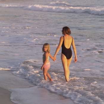 Mother and daughter walking in the ocean