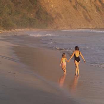 Mother and daughter walking on the beach in Costa Rica