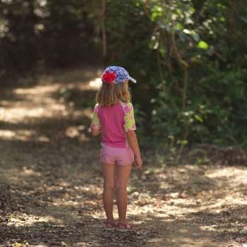 Six year old girl walking through forest in Costa Rica