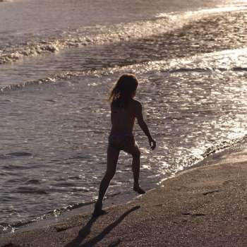 Girl running along seashore in Costa Rica