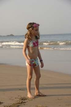 Seven year old girl standing on the beach