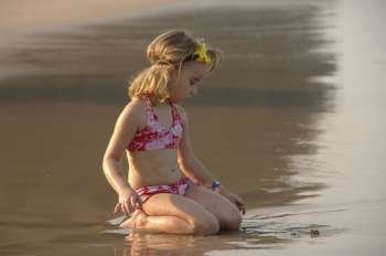 Five year old girl playing in sand