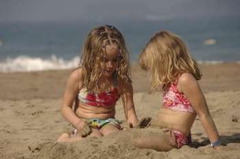 Two girls playing in sand