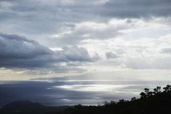 View of island in Pacific ocean with clouds from Maui, Hawaii.