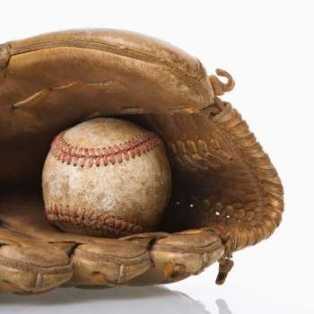 Baseball resting in baseball glove.