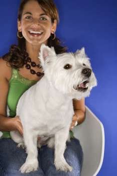Caucasian prime adult female holding white terrier dog.