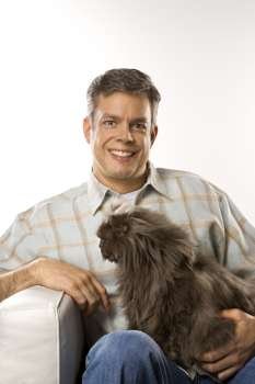 Mid-adult Caucasian man sitting holding Persian cat.