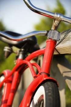 Image of red bike leaning against railing of boardwalk.