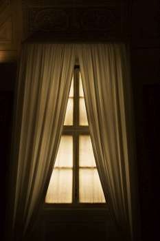 Dimly lit window with drapes in the Vatican Museum, Rome, Italy.