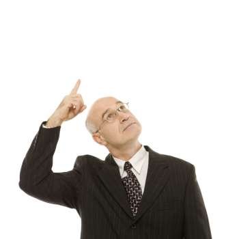 Caucasian middle-aged businessman looking and pointing up standing against white background.