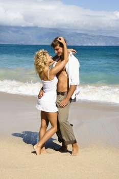 Attractive couple in sensual embrace on Maui, Hawaii beach.