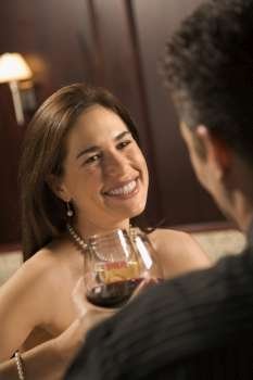 Mid adult Caucasian couple holding wine glasses and smiling.