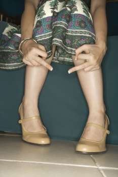 Arms and legs of Caucasian young adult female making obscene gesture.