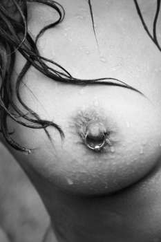 Close up of young adult Caucasian female breast with pierced nipple.