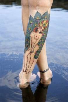 Close up of Caucasian woman´s legs covered with sexy tattoos.