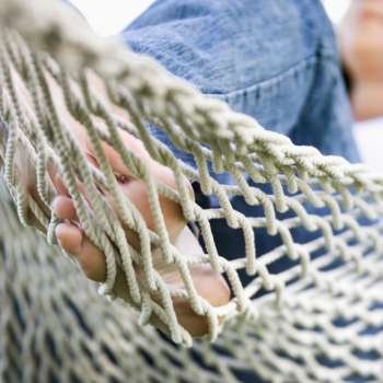 Close up of young adult Caucasian female feet in hammock.