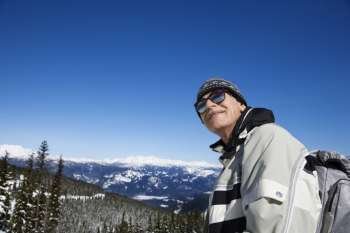 Caucasian senior man skier posing on mountain.