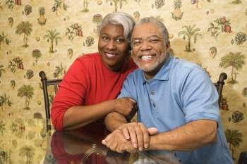 Portrait of mature African American couple embracing and smiling at viewer.