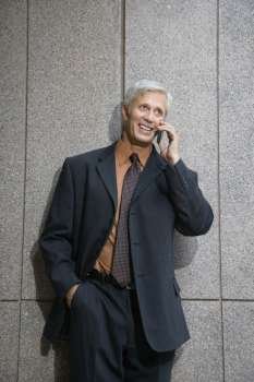 Caucasian middle aged businessman on cell phone smiling.
