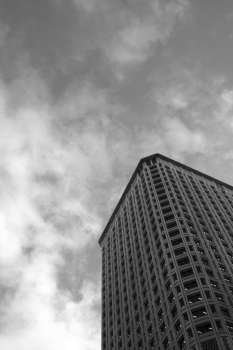 A corporate building with dark clouds (in black and white)