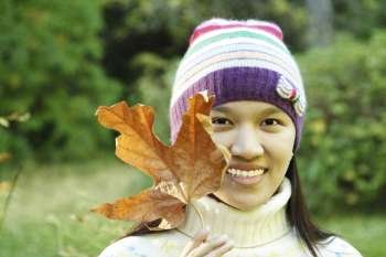 A pretty woman holding an autumn/fall leaf